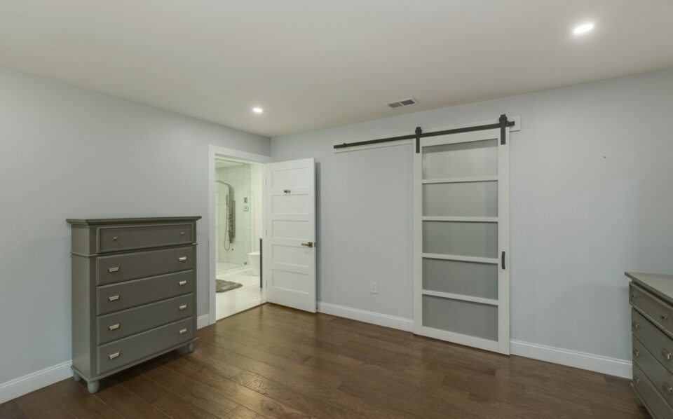Bedroom after remodel - recessed lighting, a sliding barn door and a new bathroom doorway