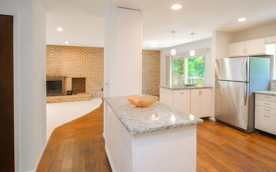 Kitchen before remodel - flat-panel cabinets and a small granite island