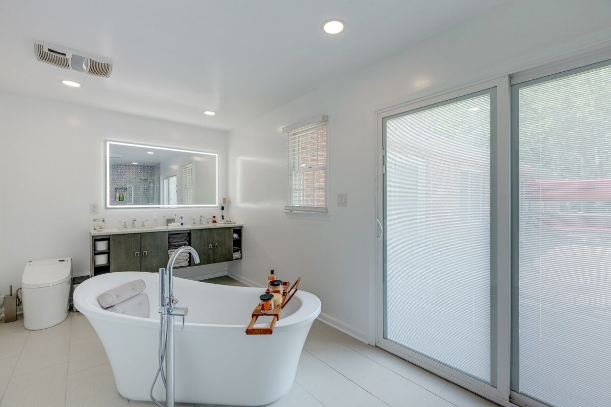 Bright bathroom with freestanding tub, floating vanity and lighted mirror