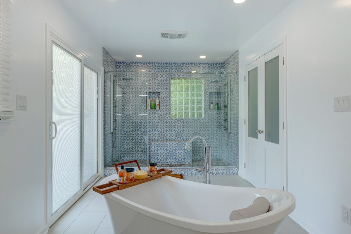 Primary bathroom with freestanding tub and blue patterned tile shower